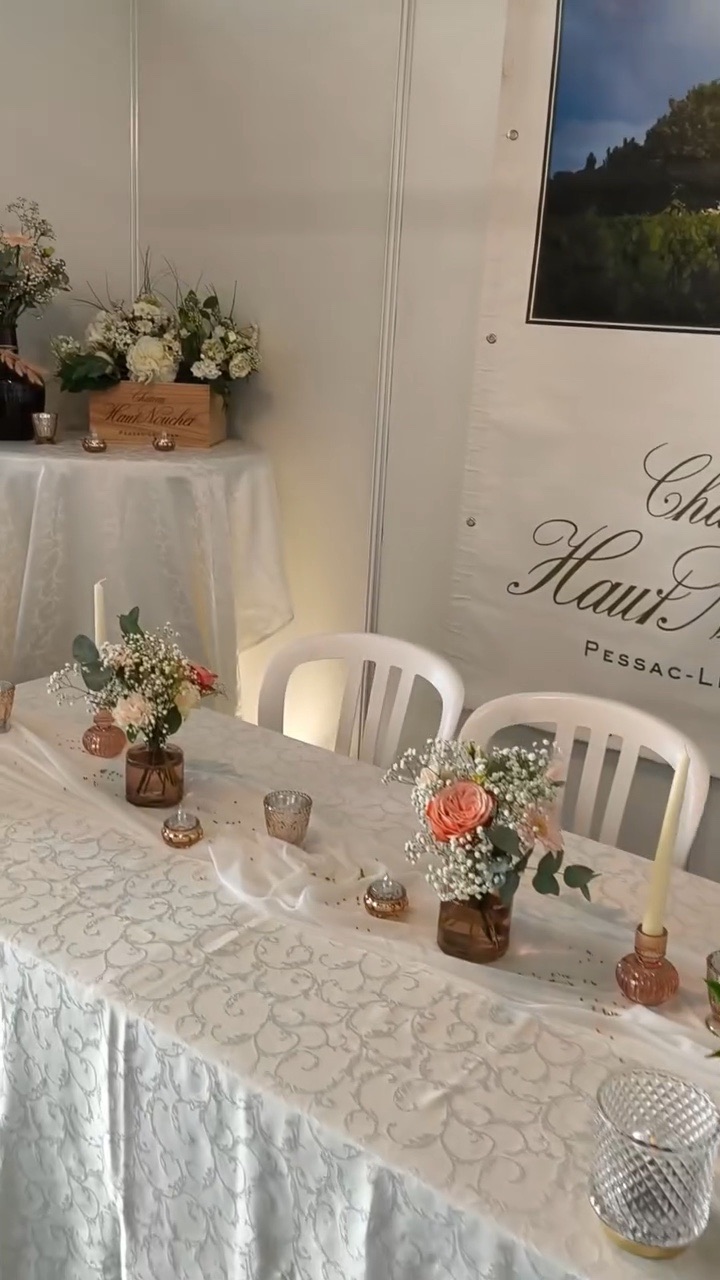 Le stand du château Haut-Nouchet au Salon du Mariage de Bordeaux : table dressée et fleurs